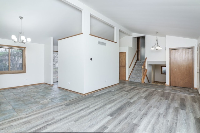 unfurnished living room featuring light hardwood / wood-style flooring, an inviting chandelier, and lofted ceiling