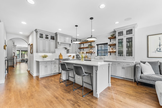 kitchen with gray cabinets, a breakfast bar, and light wood-type flooring