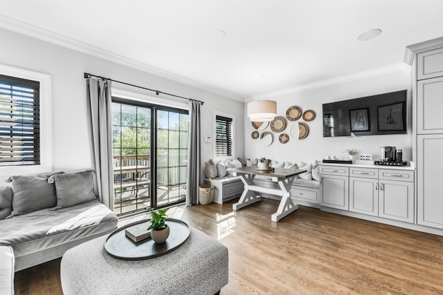 living room with light hardwood / wood-style flooring and crown molding