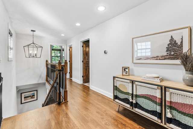 hall with a notable chandelier and hardwood / wood-style floors