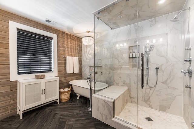 bathroom with wood walls, parquet floors, and separate shower and tub