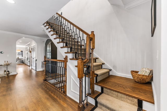 stairs featuring ornamental molding and wood-type flooring