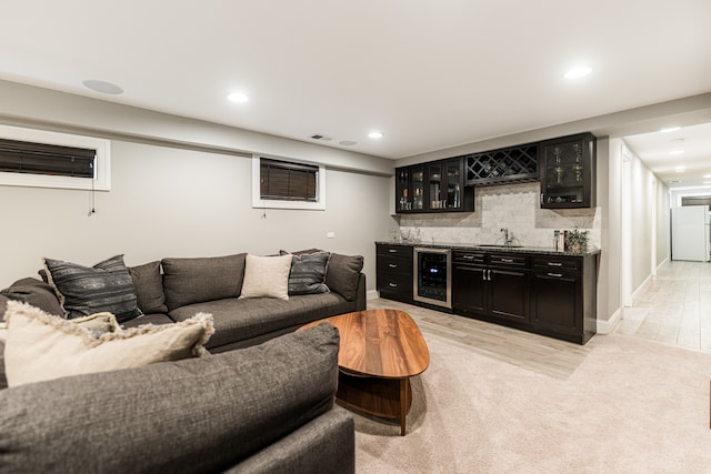 living room with wet bar, light wood-type flooring, and beverage cooler