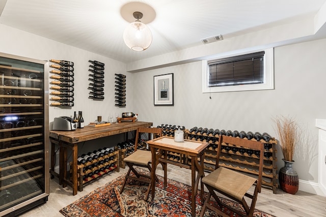 wine room featuring light hardwood / wood-style flooring and beverage cooler