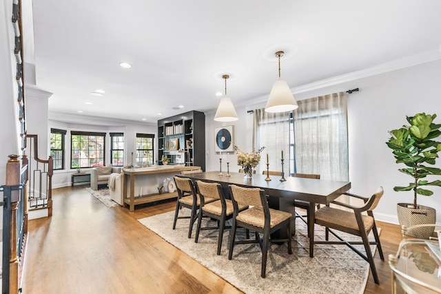 dining space featuring hardwood / wood-style floors and crown molding