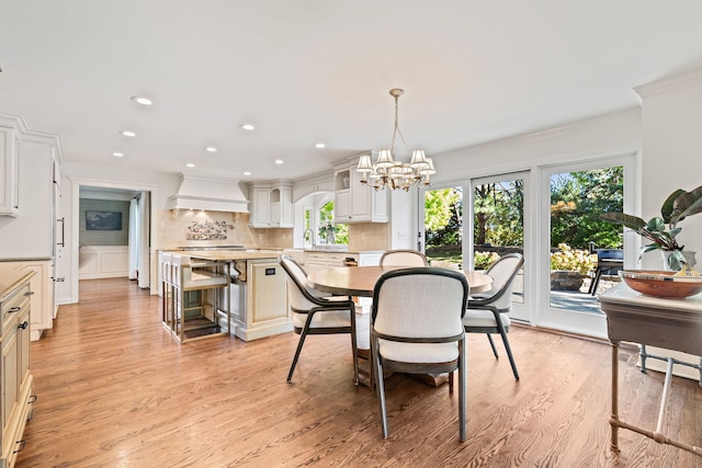 dining room featuring an inviting chandelier, sink, and light wood-type flooring