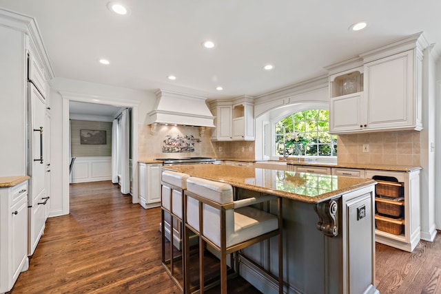 kitchen featuring white cabinetry, a center island, premium range hood, and dark hardwood / wood-style flooring