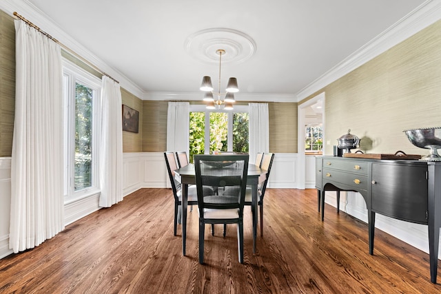 dining space with crown molding, a notable chandelier, and wood-type flooring