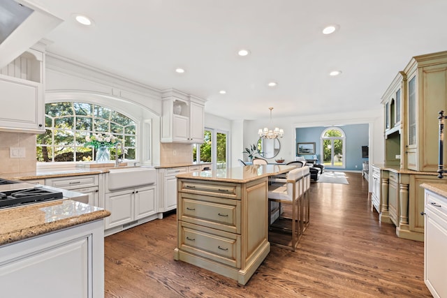 kitchen featuring a center island, sink, backsplash, and pendant lighting