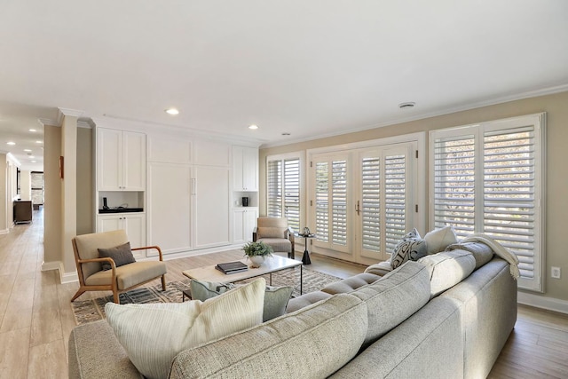 living room with ornamental molding and light hardwood / wood-style flooring