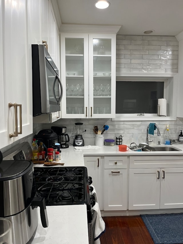 kitchen with white cabinetry, sink, dark hardwood / wood-style floors, and tasteful backsplash