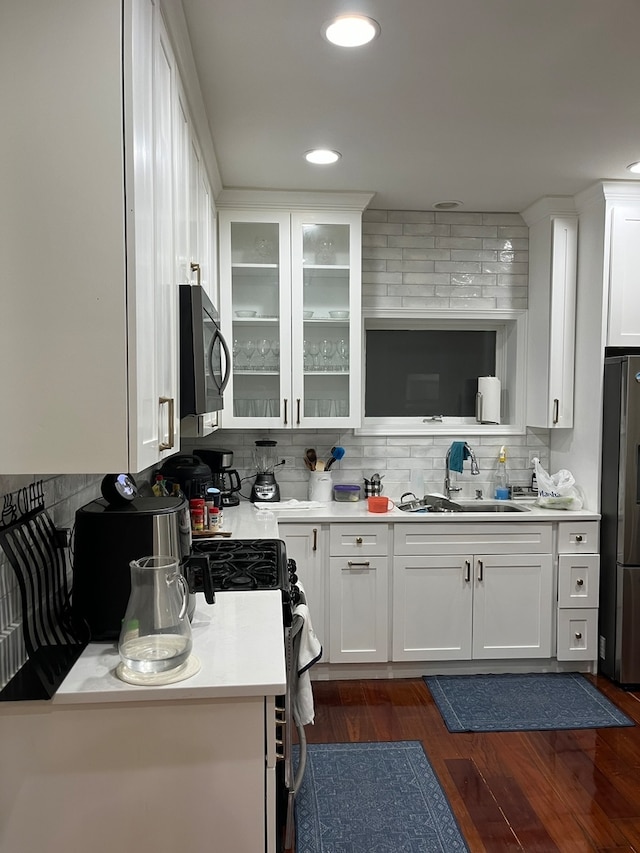 kitchen with stainless steel appliances, white cabinets, sink, and dark hardwood / wood-style flooring