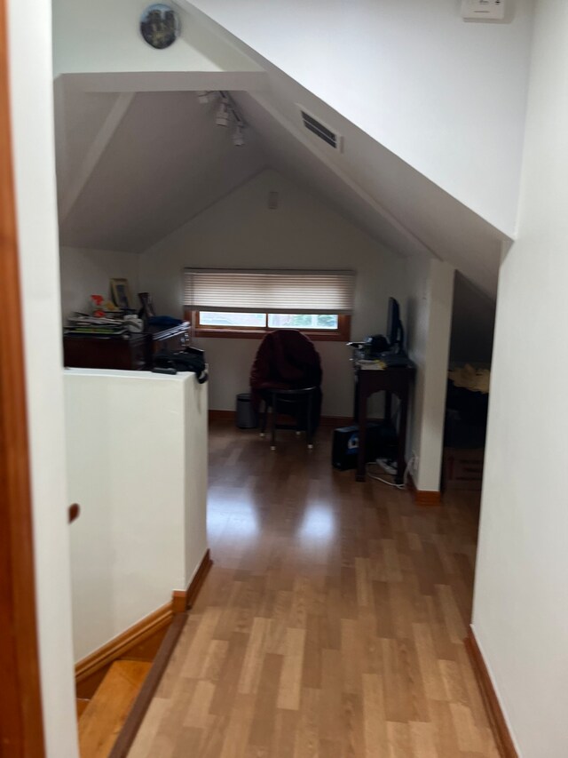 corridor featuring lofted ceiling and light hardwood / wood-style floors