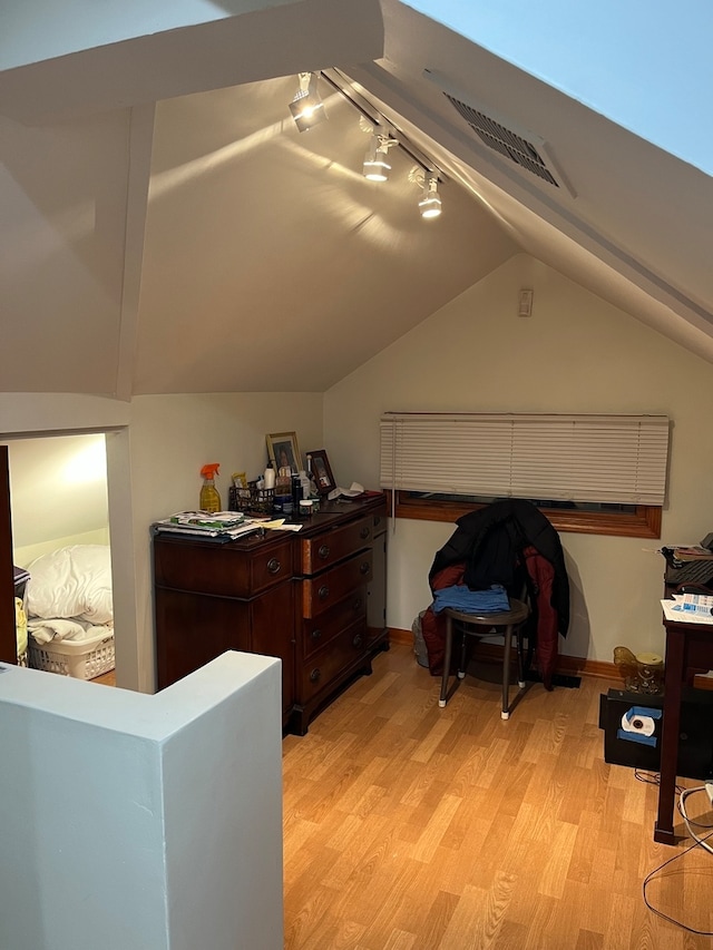 interior space featuring light wood-type flooring and vaulted ceiling