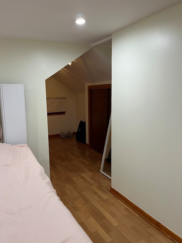 bedroom featuring lofted ceiling and hardwood / wood-style flooring