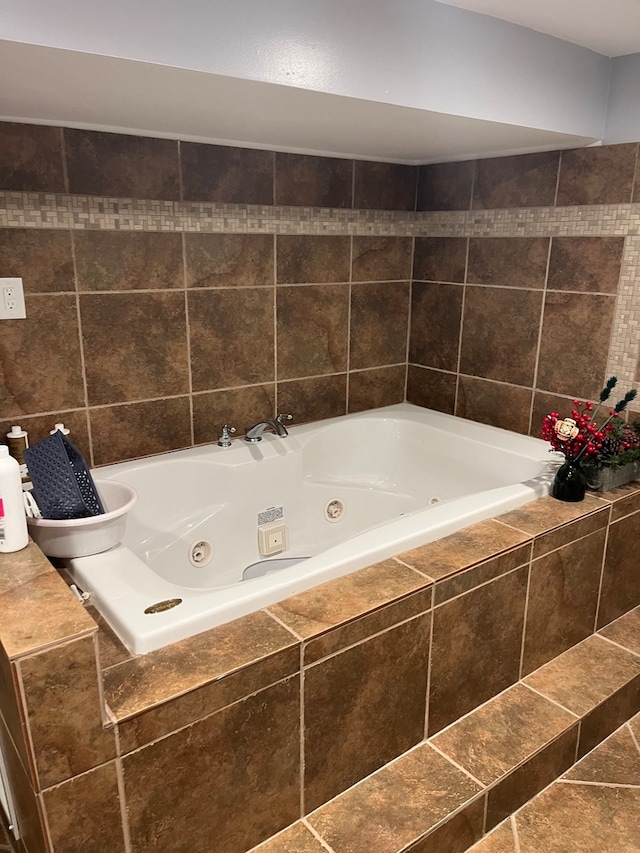 bathroom featuring tiled bath and tile patterned flooring