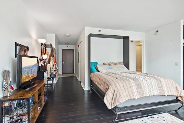 bedroom with dark hardwood / wood-style flooring