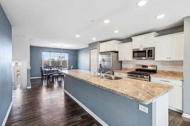 kitchen with sink, stainless steel appliances, dark hardwood / wood-style floors, decorative light fixtures, and white cabinets