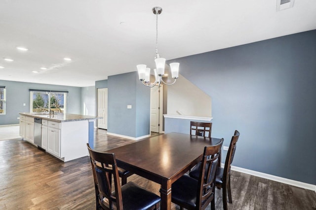 dining area featuring dark hardwood / wood-style flooring and an inviting chandelier