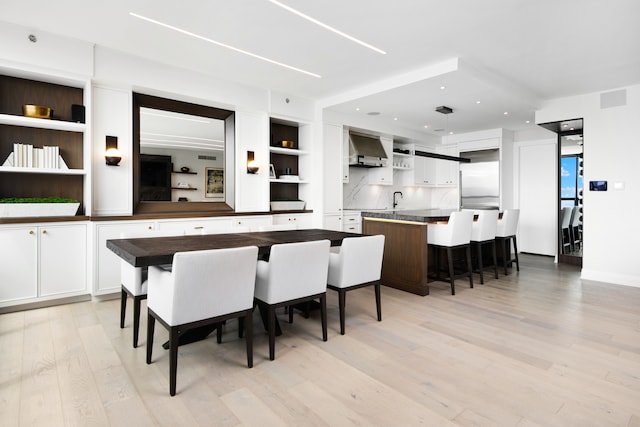 dining room with light wood-type flooring and sink