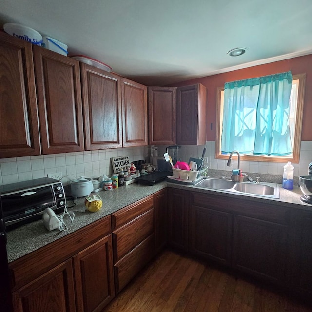 kitchen with tasteful backsplash, sink, and dark hardwood / wood-style flooring