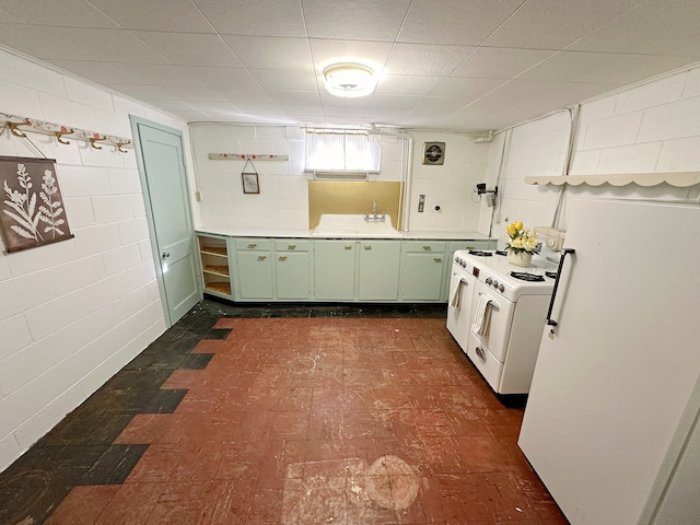 kitchen with white fridge, washer / clothes dryer, and green cabinets