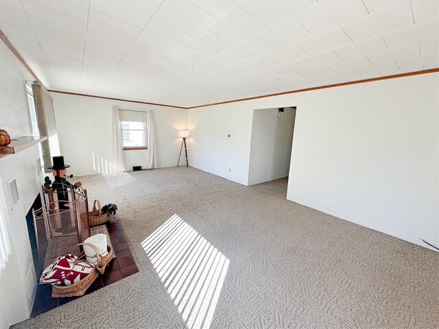 unfurnished living room featuring crown molding and carpet floors