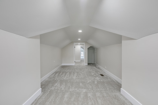 additional living space with light carpet and lofted ceiling