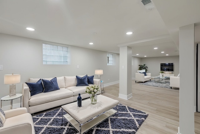 living room featuring light wood-type flooring and a healthy amount of sunlight