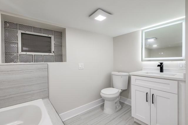 bathroom with a bathtub, hardwood / wood-style flooring, vanity, and toilet