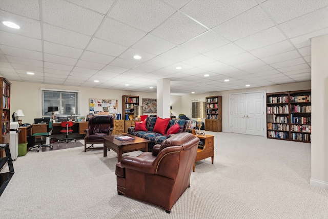 living room with a drop ceiling and carpet flooring