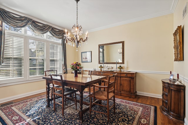 dining room featuring dark wood-type flooring, ornamental molding, and an inviting chandelier