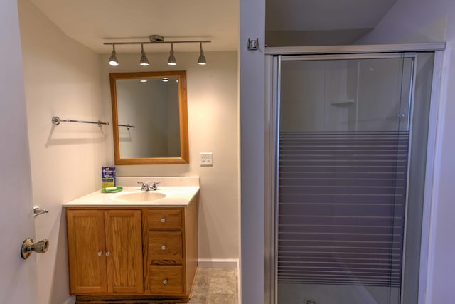 bathroom featuring a shower with door and vanity