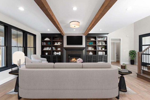 living room with beamed ceiling and light wood-type flooring