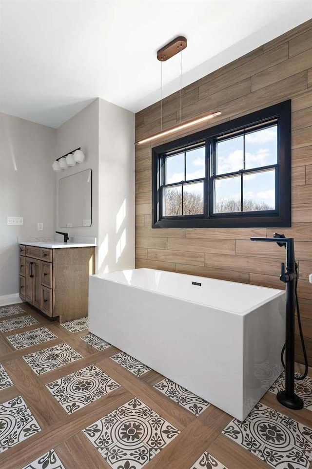 bathroom with vanity, wood walls, and a tub