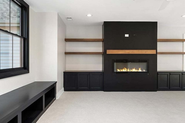 unfurnished living room with light carpet and ceiling fan