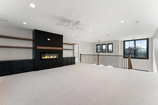 unfurnished living room featuring ceiling fan, carpet floors, and a fireplace