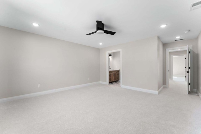 unfurnished bedroom featuring light carpet, connected bathroom, and ceiling fan