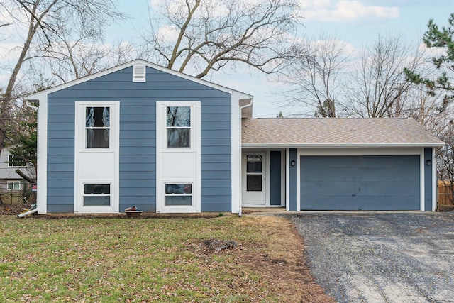 split level home featuring a garage and a front lawn