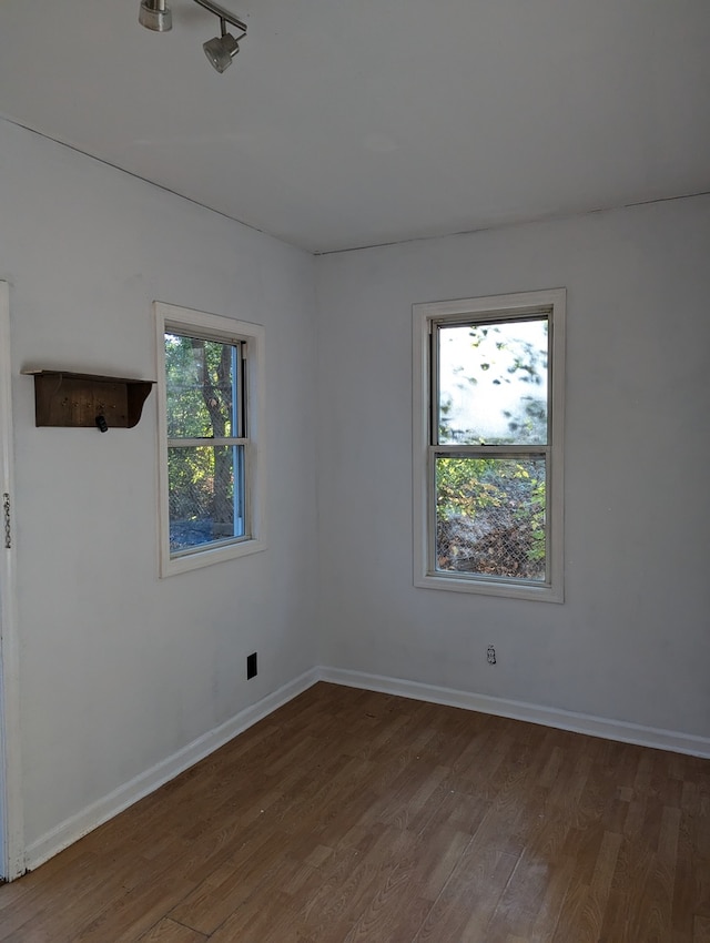 unfurnished room with dark hardwood / wood-style flooring and a healthy amount of sunlight