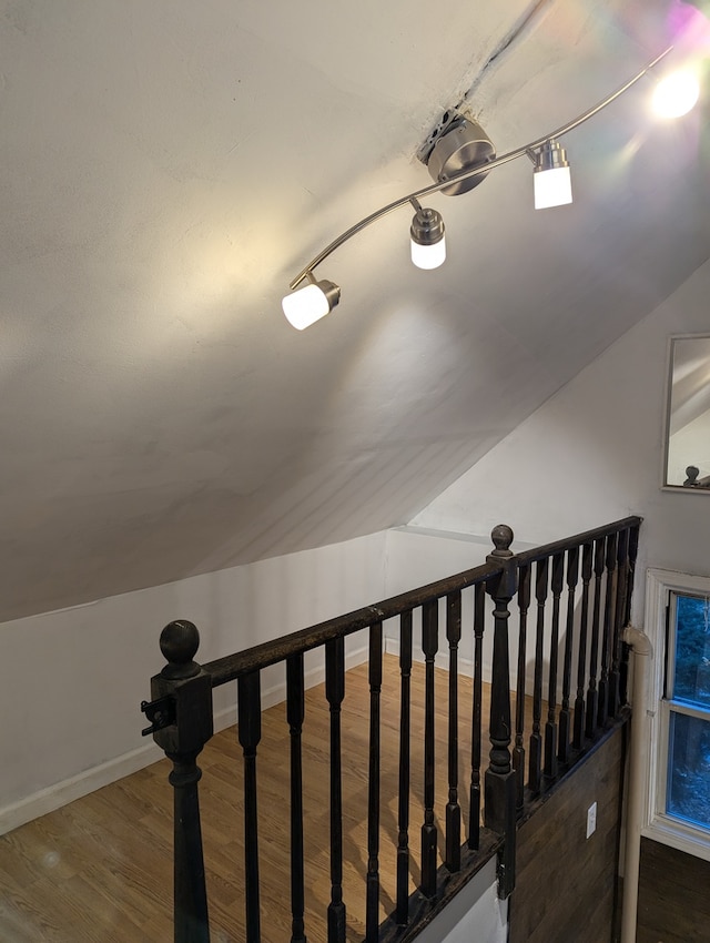 stairs with hardwood / wood-style flooring and vaulted ceiling