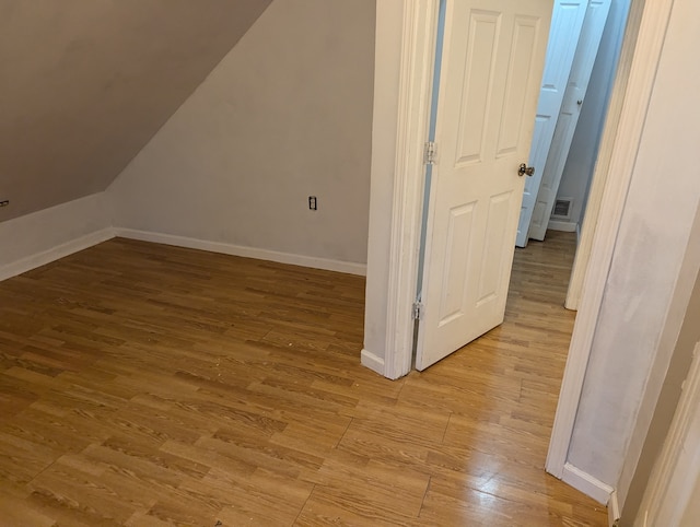 additional living space with light hardwood / wood-style flooring