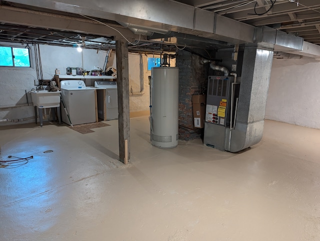 basement featuring sink, gas water heater, independent washer and dryer, and heating unit