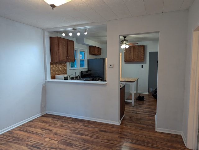 kitchen featuring stainless steel refrigerator, ceiling fan, backsplash, dark wood-type flooring, and black range with gas stovetop