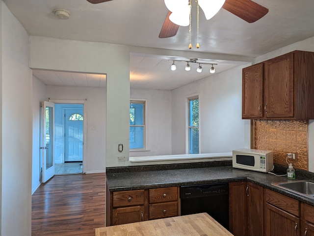 kitchen featuring black dishwasher, kitchen peninsula, tasteful backsplash, dark hardwood / wood-style floors, and ceiling fan