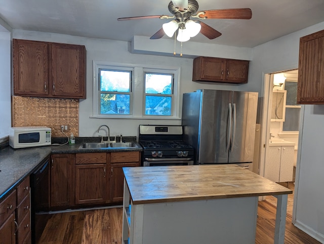 kitchen with decorative backsplash, appliances with stainless steel finishes, sink, and dark hardwood / wood-style floors