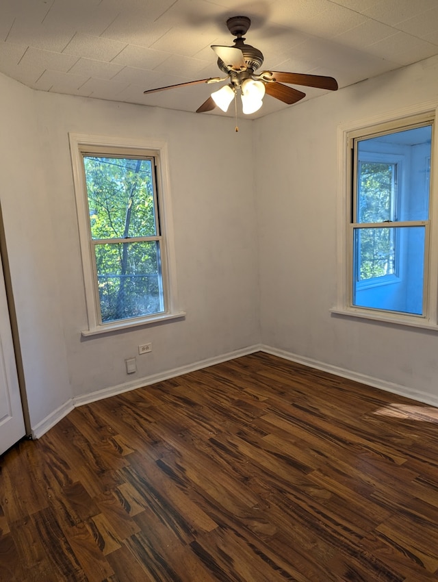 empty room with dark wood-type flooring and ceiling fan