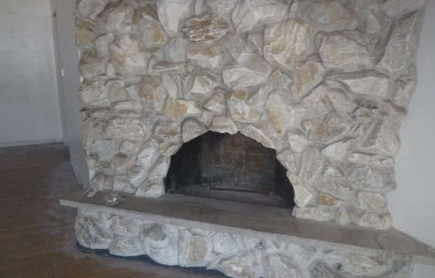 room details featuring a stone fireplace and hardwood / wood-style floors