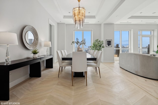 dining room featuring ornamental molding, a chandelier, light parquet flooring, and a raised ceiling