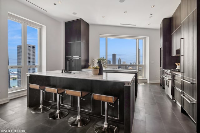 kitchen with appliances with stainless steel finishes, a healthy amount of sunlight, and a center island with sink